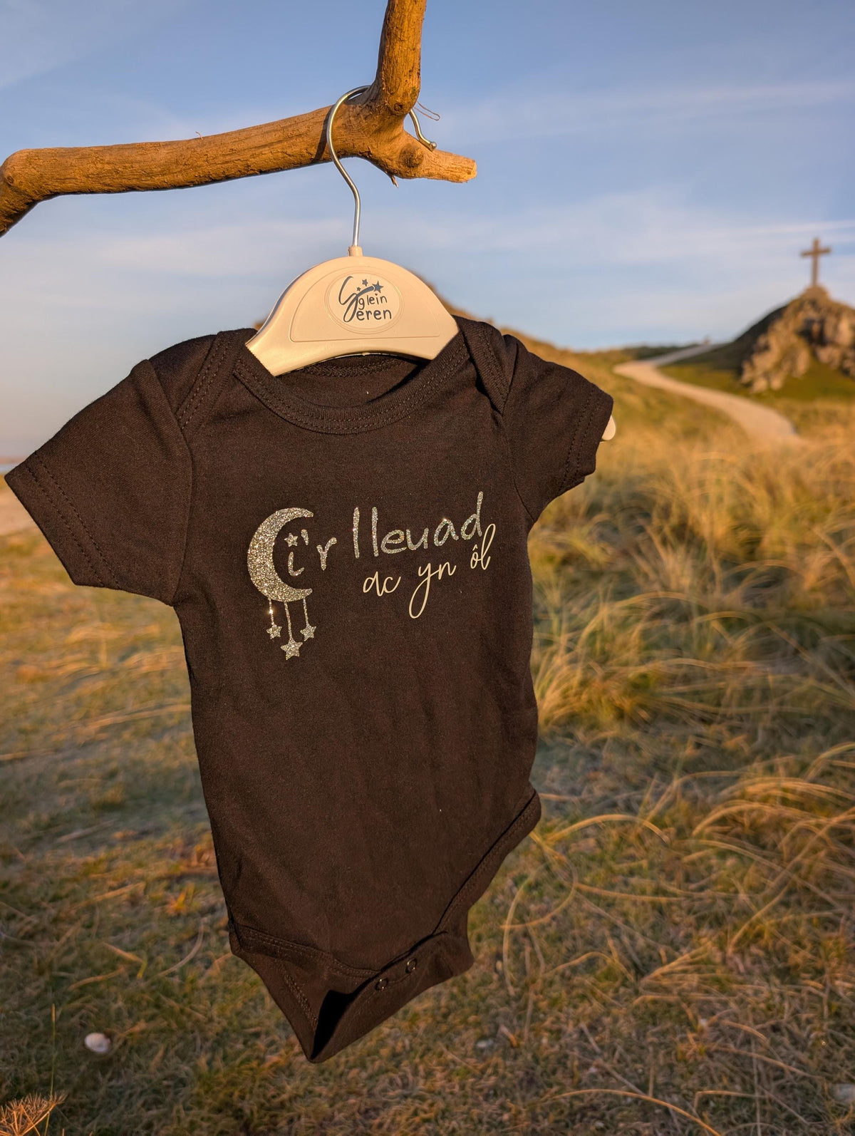 Ir lleuad ac yn ôl Welsh Moon & Stars Baby Onesie – Black, Glitter Print, Santes Dwynwen Collection
